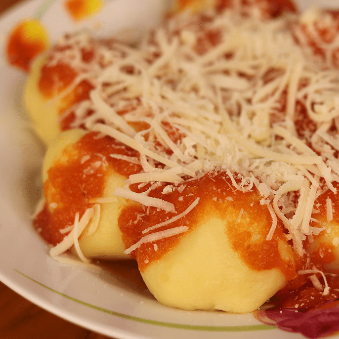 Deliciosa massa de nhoque com molho vermelho e queijo ralado, imagem destacada no blog do Pastifício Raviollini, guia de massas italianas no Mooca e Tatuapé.